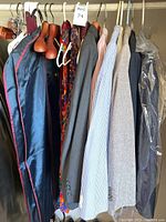 Photo showing various suit coats including blue seersucker, patterned ties, and assorted hangers.