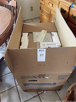 Large Kenmore branded cardboard box partially open showing styrofoam packaging and some microwave parts inside.