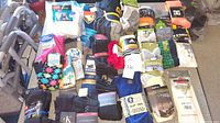 Wide view of approximately 40 pairs of new socks various types and styles spread on table including dress, sport, crew, and hiking