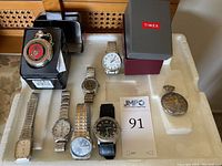 Overview of all 8 watches (2 pocket watches, 6 wrist watches) arranged on tray