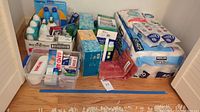 Photo of all bathroom and personal care supplies including toilet paper, facial tissues, mouthwash, body wash, bandages, lotion, dental floss, and boxed tissues.