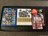 Three Beatles books displayed side by side: 'The Beatles Album' by Alisa Delano, 'The Complete Beatles Chronicle', and 'P.S. We Love You: The Beatles Story 1962-3'.