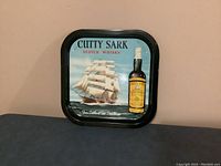 Photo showing a square metal tray featuring colorful artwork of a sailing ship and a bottle of Cutty Sark Scotch Whisky.