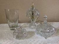 Four crystal pieces including vase, lamp, small and large candy dishes