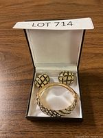 Full set of bracelet and earrings inside black jewelry box with white satin interior.