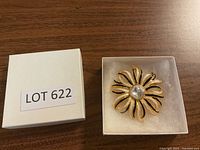 Closed white box labeled Lot 622 containing the brooch.