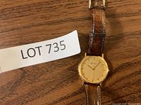 Front view of the Bulova men's wristwatch showing the gold-tone dial and brown leather strap.