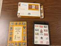 Photo showing the orange-covered stamp album labeled "Postage Stamps of the World" alongside a black display folder with Canadian stamps.