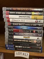 Photo of stacked PS3 and PS4 game cases showing spine titles and cases