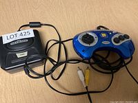 Photo of Sega Genesis console with attached cables and blue wired controller.