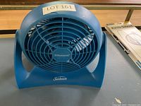 Front view of blue Sunbeam electric fan showing front grill and Sunbeam logo