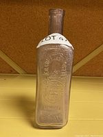 Front view of the vintage E.B. Shuttleworth pharmacy bottle showing embossed text and crown logo.