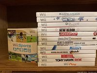 Photo showing stacked Wii game cases including titles and spines.