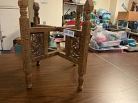 Photo of the complete wooden folding plant stand showing carved legs and rectangular side panels with floral carvings.