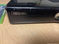 Front view of black Xbox 360 console showing Xbox 360 branding