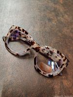 Close-up image of translucent tortoiseshell patterned reading glasses with 2.50 strength lenses.