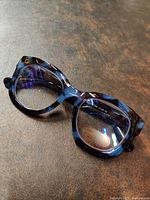 Close-up front view of reading glasses showing translucent tortoiseshell pattern frames and rectangular lenses.