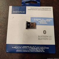 Front view of packaged Insignia Bluetooth 5.0 USB Adapter showing product brand, compatibility with Windows PCs and laptops, and Bluetooth 5.0 specification.