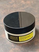 White jar with black lid labeled COSRX Advanced Snail Hydrogel Eye Patch.