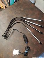 Full view of the four individual LED grow lamps with flexible arms joined at a single base connected to power adapter.