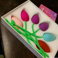 Full set of six different colored Kegel exercise balls in a white foam tray inside a box.
