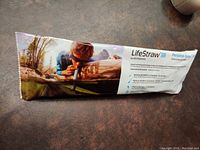 LifeStraw packaged in a sealed plastic wrapper with outdoor survival use imagery and product name visible.