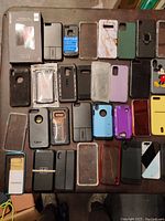 Photo showing a variety of cell phone cases including black, grey, clear, purple, and patterned designs in multiple materials.