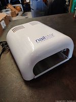 Photo showing white NailStar Professional UV nail curing station with ventilation slits and logo on top.