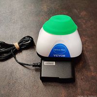 VEVOR vortex mixer unit with green silicone cover and attached power adapter on a grey surface.