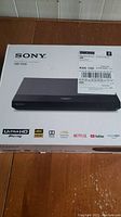 Box of Sony UBP-X700 Ultra HD Blu-ray DVD player showing product image and model number