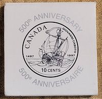 White square protective case bearing the inscription '500th ANNIVERSARY 1497-1997' with a sailing ship design and denomination of 10 cents.