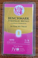 Gold bar sealed in a Benchmark Strategic Metals certificate card with product and authenticity details