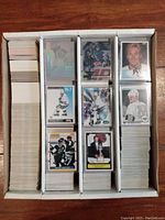 Rows of hockey cards organized in long cardboard storage boxes with some featured Wayne Gretzky cards on top, displaying various designs and conditions.