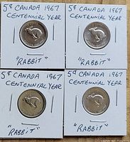 Four Canadian 5-cent coins dated 1967 in holders labeled 'Rabbit' and 'Centennial Year'