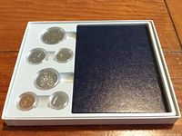 White plastic display case containing six Canadian coins and a blue cover insert.