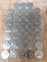 Top view of 38 Canadian five cent coins arranged in rows showing various dates and reverse designs.