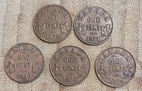Photo showing five Canadian one cent pennies with dates 1920, 1921, 1927, 1928, and 1929.