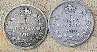 Two Canadian 5 cent coins dated 1910 showing the reverse with denomination, date, crown and wreath.