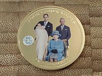 Full clear image of the 2014 gold plated crown coin showing the four generations of royalty including Queen Elizabeth II, Prince Charles, Prince William, and an infant. The platinum privy mark is visible to the left. The coin's edge text is clearly readable.