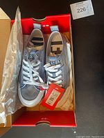 Pair of grey Diesel men's running shoes new in box, with white laces and attached tags.