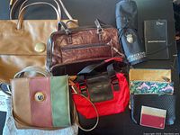 Top view photo displaying all purses, bags, makeup brush holders, and small makeup accessories arranged on a gray surface.