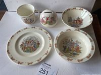 Photo of entire 5-piece Bunnykins Royal Doulton dish set including two bowls, plate, mug, and coin bank.
