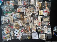 Image showing a large assortment of vintage and novelty buttons in various shapes, sizes, colors, and themes, mostly packed in small plastic bags or original packaging.