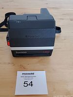 Front and top view of the black Polaroid Sun 600 LMS instant camera showing model name and Polaroid logo.