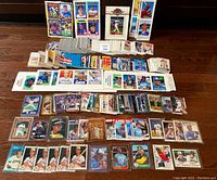 Lot overview showing a wide assortment of baseball cards spread out on a wooden floor with a label in the center showing number 39.