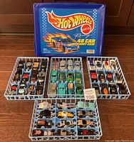 Full overview of the 48 cars in 4 blue trays with 1997 Hot Wheels carrying case in background