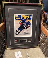 Front view of framed autographed hockey photo with nameplate and pins.