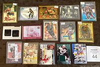 Full view of 17 hockey cards in plastic sleeves laid out showing various inserts and parallel cards with multiple players and some cards containing jersey swatches
