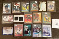Photo showing 15 hockey cards including Patrick Roy, Joe Thornton, Brett Hull, and others, some featuring jersey patches and price stickers.