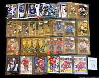 Full spread of 54 hockey rookie cards arranged in rows on black background. Visible gold and black diamond rookie cards along with others.